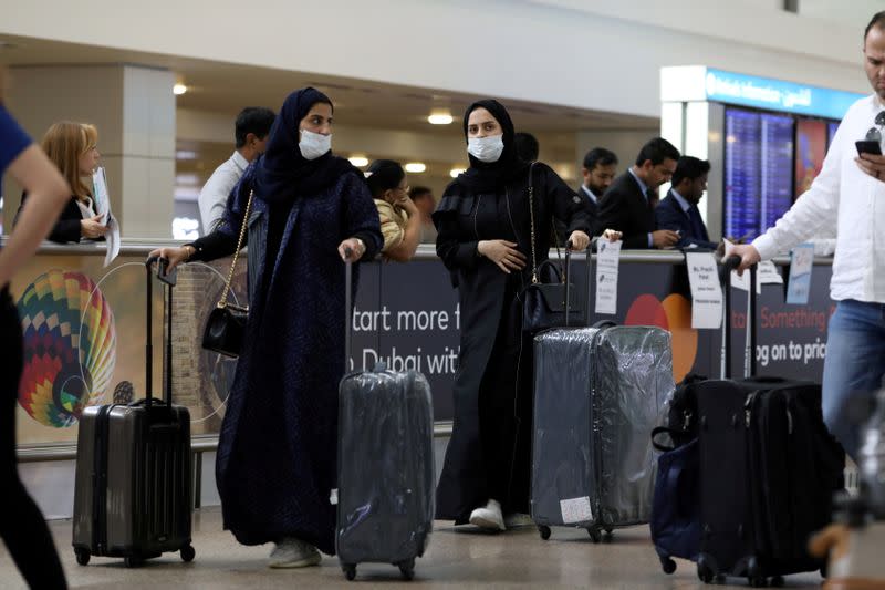 Travellers wear masks as they arrive at Dubai International Airport, after the UAE's Ministry of Health and Community Prevention confirmed the country's first case of coronavirus, in Dubai