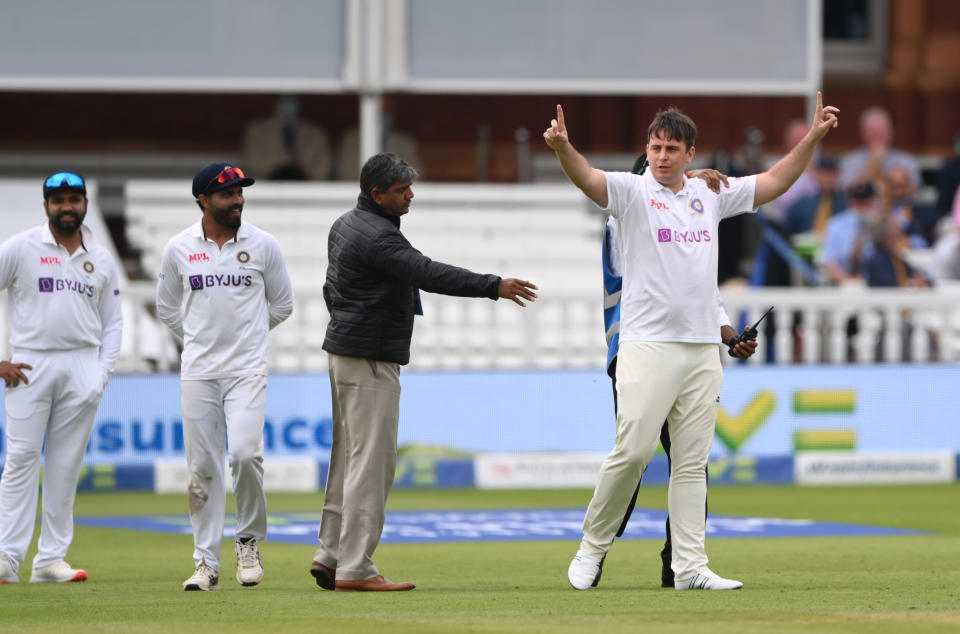 LONDON, ENGLAND - AUGUST 14: A spectator dressed in an India shirt and whites, makes his way onto the middle of the field before being escorted off before the afternoon session during day three of the Second Test Match between England and  India at Lord's Cricket Ground on August 14, 2021 in London, England. (Photo by Stu Forster/Getty Images)