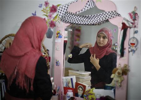 Isra Al-Modallal, a spokeswoman of the Hamas government in Gaza, prepares herself before heading to the office, at her house in Rafah refugee camp in the southern Gaza Strip November 10, 2013. REUTERS/Ibraheem Abu Mustafa