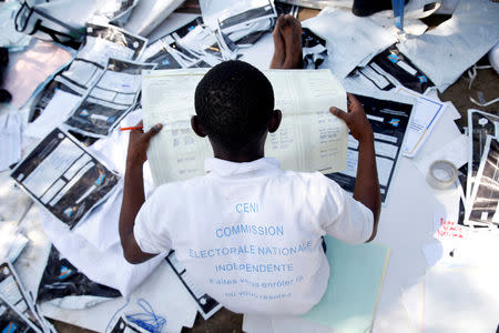 A man examines voting materials at Congo's Independent National Electoral Commission (CENI) tallying centre in Kinshasa, Democratic Republic of Congo, January 1, 2019. REUTERS/Baz Ratner/Files