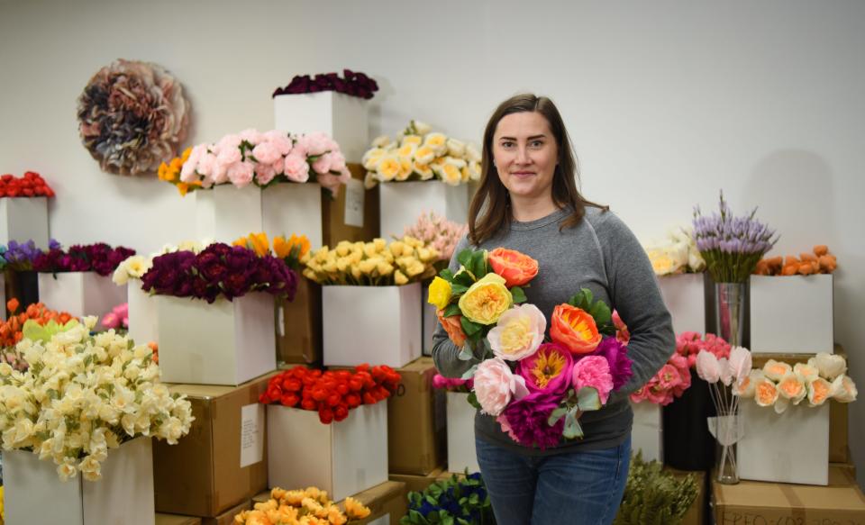 Liz Carter of Unwilted in Holt poses for a portrait Thursday, Nov. 11, 2021, at her new workspace.  She designs flowers and floral arrangements that are individually hand-crafted from Italian crepe paper.