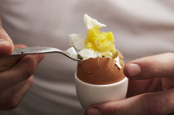 Someone about to eat a cracked hard-boiled egg