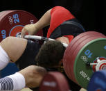 Matthias Steiner of Germany gets hit by the weights while failing to make a successful lift in the men's over 105-kg, group A, weightlifting competition at the 2012 Summer Olympics, Tuesday, Aug. 7, 2012, in London. (AP Photo/Mike Groll)