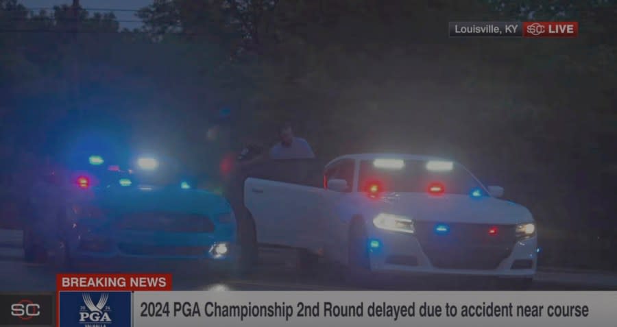 In this still image made from video provided by ESPN, Masters champion Scottie Scheffler is escorted to a police car after being handcuffed near Valhalla Golf Club, site of the PGA Championship golf tournament, early Friday, May 17, 2024. (ESPN via AP)