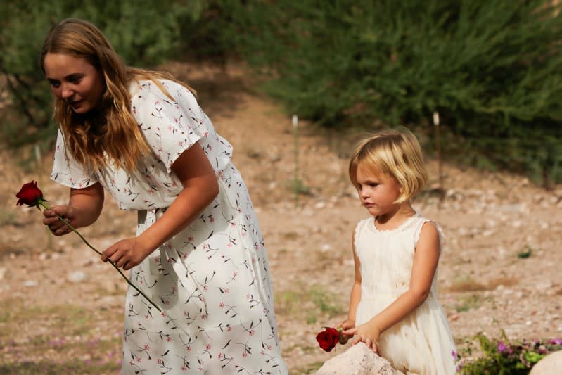 A child holds a flower during the funeral of Dawna Ray Langford and her sons Trevor, Rogan, who were killed by unknown assailants, at the cemetery in La Mora