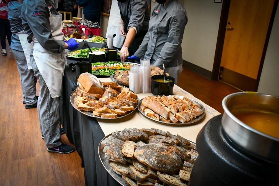 Volunteers organize food on tables during the Sun Soil Water Ag Summit in November 2021.