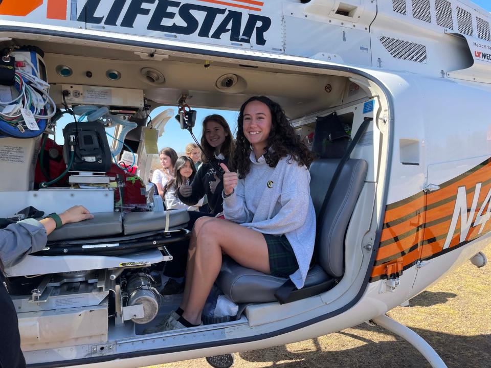 Ann-Marie Shipp and Ellie Jones, members of the Irish Medicine Club, explore the interior of UT LIFESTAR helicopter.