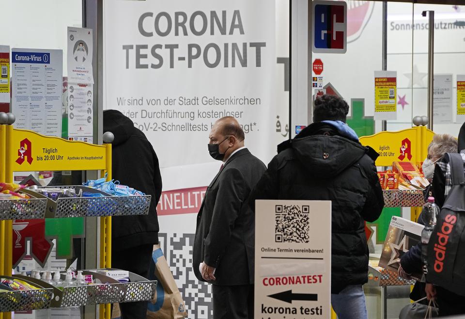 A man walks into a pharmacy, that offers corona tests in Gelsenkirchen, Germany, Friday, Nov. 12, 2021. Germany plans to bring back free Covid-19 rapid tests. (AP Photo/Martin Meissner)