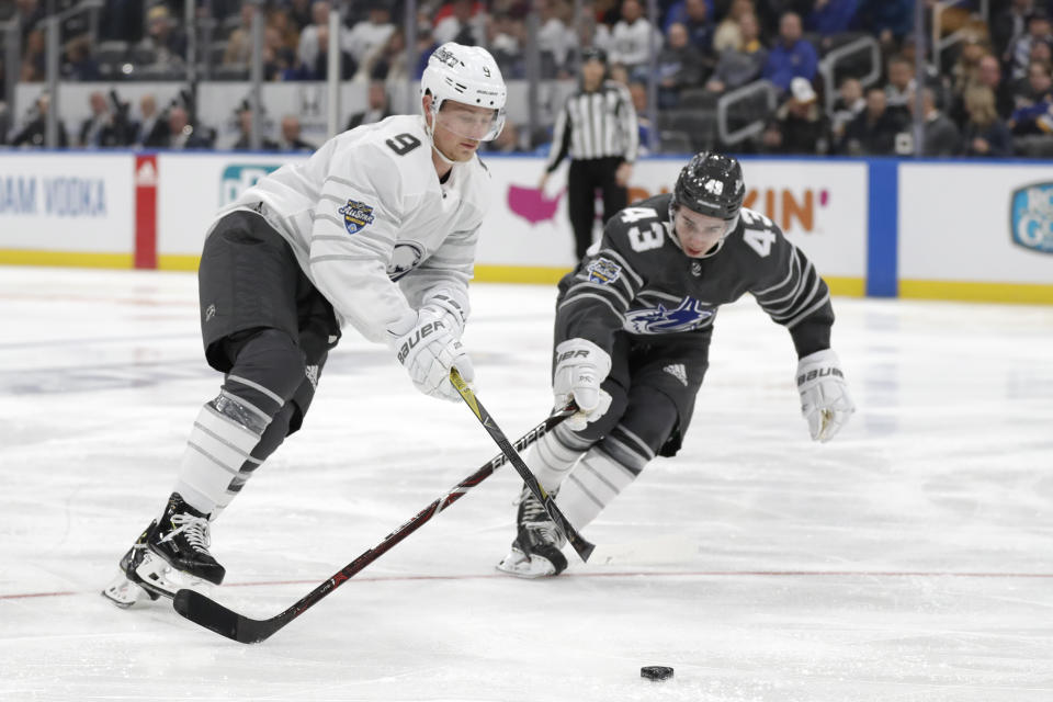 Buffalo Sabres forward Jack Eichel (9) battles for the puck with Vancouver Canucks defender Quinn Hughes (43) in the NHL hockey All Star final game Saturday, Jan. 25, 2020, in St. Louis. (AP Photo/Jeff Roberson)