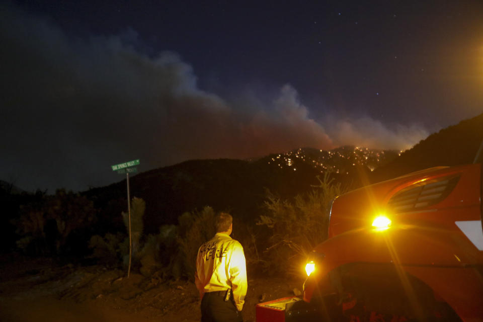 A firefighter watches as the Sheep fire burns in Wrightwood, Calif., Monday, June 13, 2022. (AP Photo/Ringo H.W. Chiu)