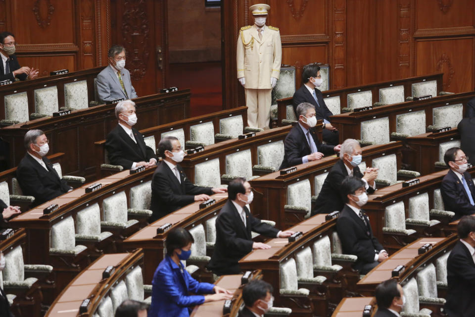 Japanese lawmakers wearing face masks to protect against the spread of the coronavirus attend an extraordinary Diet session at the upper house of parliament in Tokyo, Monday, Oct. 26, 2020. (AP Photo/Koji Sasahara)
