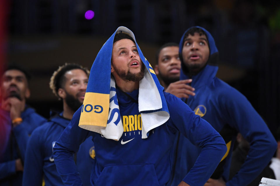 Golden State Warriors guard Stephen Curry looks at a replay along with teammates during the second half of a preseason NBA basketball game against the Los Angeles Lakers Wednesday, Oct. 16, 2019, in Los Angeles. The Lakers won 126-93. (AP Photo/Mark J. Terrill)