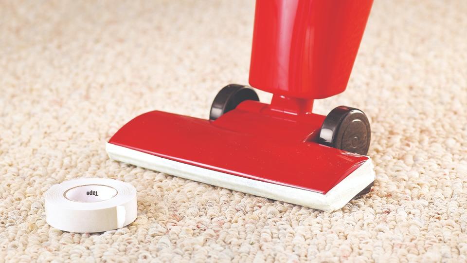 Masking tape on a vacuum protects a wall from scuffs