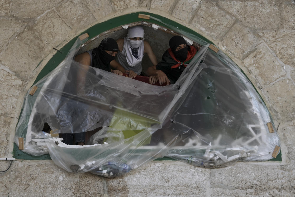 Masked Palestinians take position during clash with Israeli security forces at the Al Aqsa Mosque compound in Jerusalem's Old City Friday, April 15, 2022. (AP Photo/Mahmoud Illean)