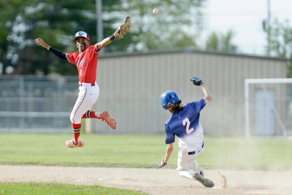 Cranston West shortstop Eddy Silverio leaps to catch an errant throw as Toll Gate's Ethan Randall slides in safely during the fourth inning of Wednesday's Division I game.