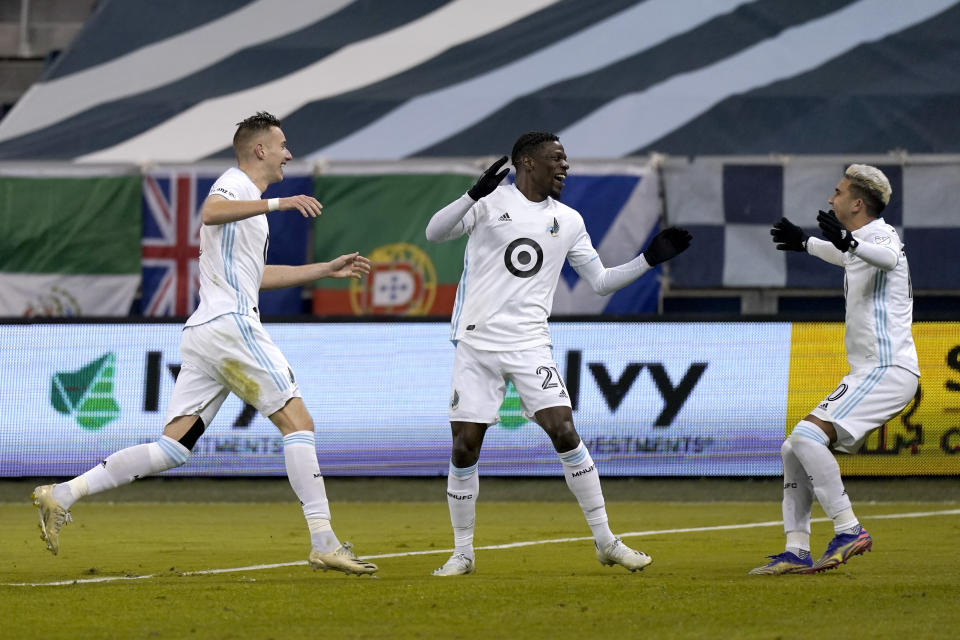 Minnesota United defender Bakaye Dibassy (21) celebrates with teammates after scoring a goal during the first half of an MLS soccer match against Sporting Kansas City on Thursday, Dec. 3, 2020, Kansas City, Kan. (AP Photo/Charlie Riedel)