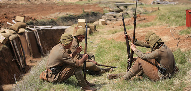 Some actors in traditional Turkish uniform take advantage of downtime between shoots.