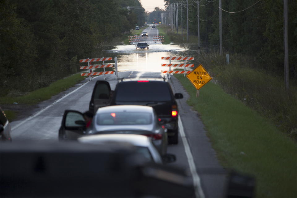 A line of cars waits in line on a flooded section of a South Carolina road.