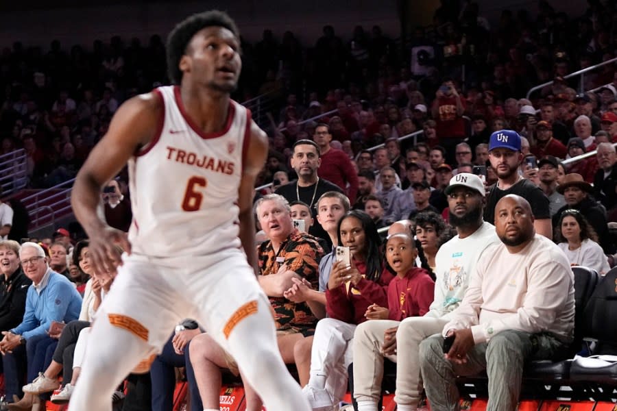 Southern California guard Bronny James, left, waits for a rebound as his father, LeBron James, third from right, watches during the first half of an NCAA college basketball game Sunday, Dec. 10, 2023, in Los Angeles. (AP Photo/Mark J. Terrill)