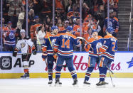 Edmonton Oilers' Leon Draisaitl (29), Mattias Ekholm (14), Zach Hyman (18) and Evan Bouchard (2) celebrate after a goal against the Anaheim Ducks during first-period NHL hockey game action in Edmonton, Alberta, Saturday, April 1, 2023. (Jason Franson/The Canadian Press via AP)