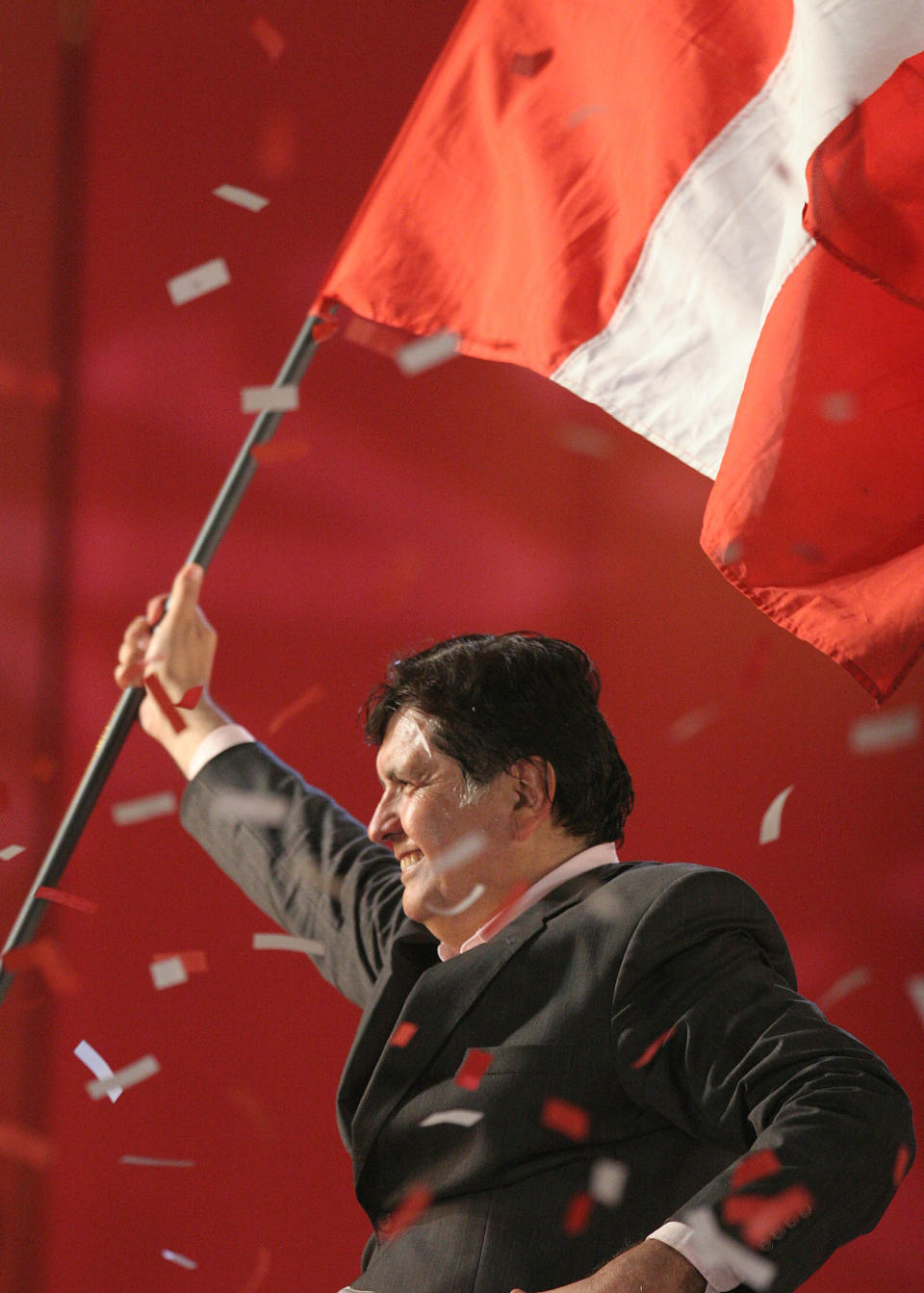 FILE - In this June 1, 2006 file photo, presidential candidate Alan García of the American Popular Revolutionary Alliance, or APRA, waves a Peruvian flag during his closing campaign rally in Lima, Peru. Current Peruvian President Martinez Vizcarra said Garcia, the 69-year-old former head of state died Wednesday, April 17, 2019, after undergoing emergency surgery in Lima. Garcia shot himself in the head early Wednesday as police came to detain him in connection with a corruption probe. (AP Photo/Lucho Gonzales, File)