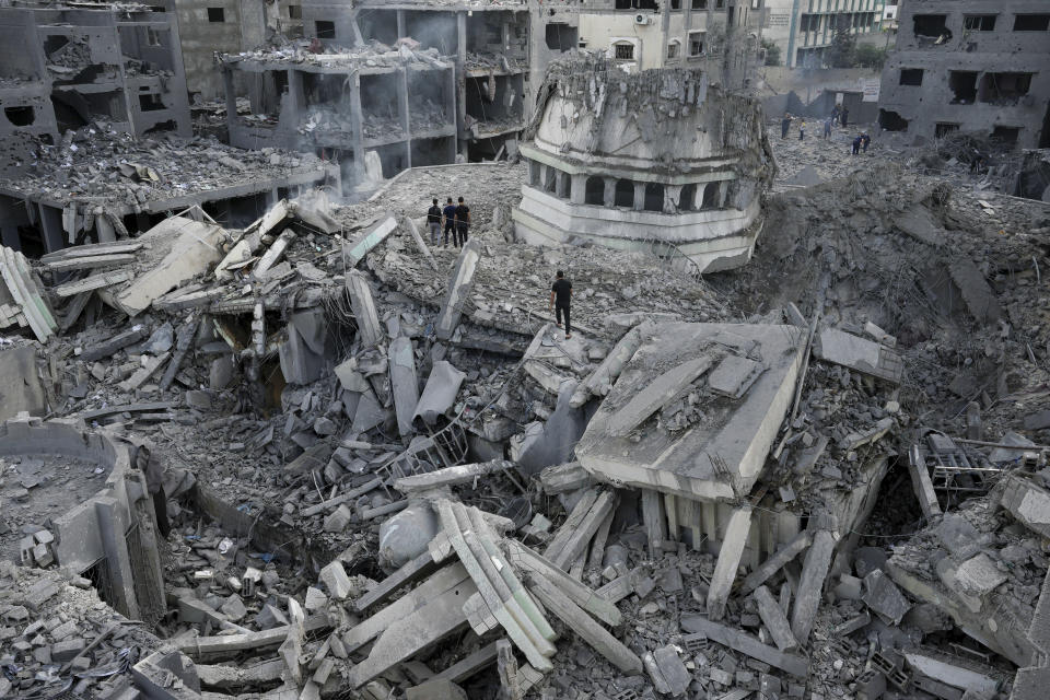 Palestinos revisan los escombros de la mezquita Yassin, la cual fue destruida por un ataque aéreo israelí en el campamento de refugiados Shati, el lunes 9 de octubre de 2023, en la Ciudad de Gaza. (AP Foto/Adel Hana)