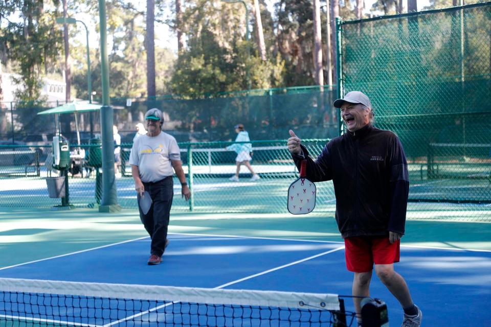 Terry Patterson, right, gives a thumbs up after scoring a point during a pickleball match with partner Ricky Snipes at The Landings Club's Franklin Creek Tennis Center on Oct. 20, 2022.