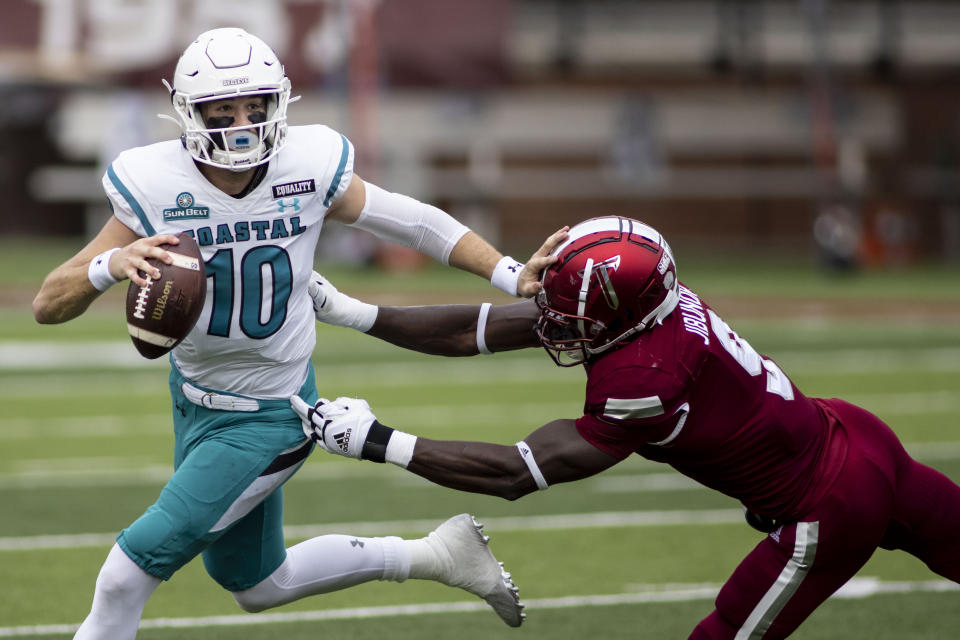 Troy defensive back Richard Jibunor (9) chases Coastal Carolina quarterback Grayson McCall (10) during an NCAA college football game, Saturday, Dec. 12, 2020, in Troy, Ala. (AP Photo/Vasha Hunt)