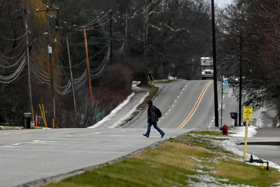 A pedestrian crosses Mount Hope Road east of Hagadorn Road on Friday, Jan. 26, 2024, in Meridian Township.