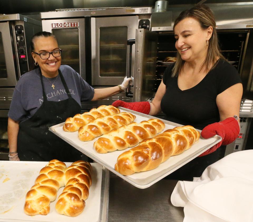 Jennifer Tsarnas and Irene Mallias look over loaves of tsourekia fresh from the oven Tuesday at Annunciation Greek Orthodox Church in Akron. The Easter bread was made with a recipe from the Kalymnian Society of Archangel Michael Greek Orthodox Church in Campbell, Ohio.