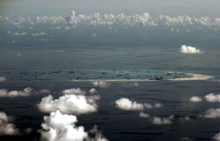 An aerial photo taken though a glass window of a Philippine military plane shows the alleged on-going land reclamation by China on mischief reef in the Spratly Islands in the South China Sea, west of Palawan, Philippines, in this May 11, 2015 file photo. REUTERS/Ritchie B. Tongo/Pool/Files