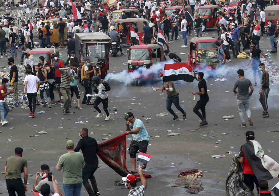 An anti-government protester prepares to throw a tear gas canister fired by Iraq security forces during a demonstration, in Baghdad, Iraq, Monday, Oct. 28, 2019. Protests have resumed in Iraq after a wave of anti-government protests earlier this month were violently put down. (AP Photo/Hadi Mizban)