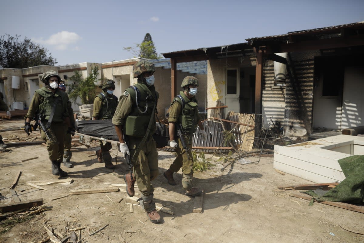 Israeli soldiers carry a body following the terror attacks by Hamas in southern Israel (Getty Images)