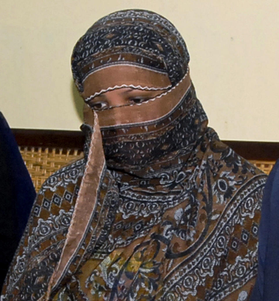 FILE - In this Nov. 20, 2010, file photo, Aasia Bibi, a Pakistani Christian woman, listens to officials at a prison in Sheikhupura near Lahore, Pakistan. Pakistani media say Aasia Bibi, a Christian woman acquitted of blasphemy after spending eight years on death row, has left Pakistan for Canada to be reunited with her daughters. Wilson Chawdhry of the British Pakistani Christian Association told The Associated Press on Wednesday, May 8, 2019, he received a telephone text message from a British diplomat stating simply that “Aasia is out.” (AP Photo, File)