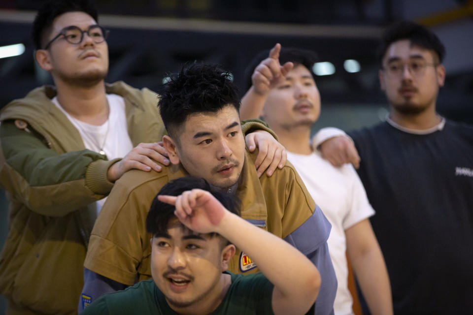 Members of the Chinese music group Produce Pandas, from top left, Husky, Mr. 17, Otter, DING, and Cass, at bottom, strike a pose while practicing dance choreography during rehearsals in Beijing, Thursday, April 15, 2021. The Produce Pandas proudly call themselves "the first plus-sized boy band in China." That's a radical departure from the industry standard set by Korean super groups such as BTS, whose lanky young members are sometimes referred to in China as "little fresh meat." (AP Photo/Mark Schiefelbein)