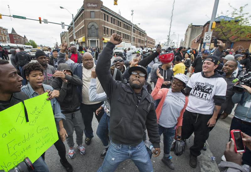 EFE/EUA CARIBE SHM19 BALTIMORE (MD, EEUU), 01/05/2015.- Varias personas celebran el anuncio de la Fiscalía de Maryland de que presentará cargos contra seis agentes de la Policía de Baltimore por la muerte del joven negro Freddie Gray, en Baltimore, este 1 de mayo de 2015. En una rueda de prensa, la fiscal estatal por Baltimore, Marilyn Mosby, dijo que Gray fue arrestado &quot;ilegalmente&quot; y formulará cargos por el posible homicidio del joven de 25 años, que no cometió delito alguno. Freddie Gray falleció el pasado 19 de abril, tras una semana en coma derivada de una lesión de columna provocada durante su arresto una semana antes. La muerte de Gray desencadenó una oleada de protestas en Baltimore que desembocaron en graves disturbios por toda la ciudad, la declaración del estado de emergencia, la imposición de un toque de queda desde el martes y centenares de detenciones. EFE/JOHN TAGGART