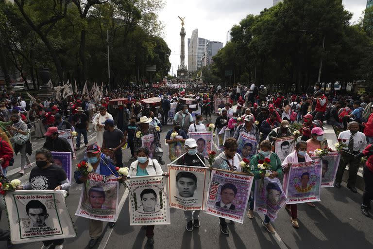 ARCHIVO - Familiares y compañeros de clase de los 43 estudiantes universitarios de Ayotzinapa desaparecidos marchan en la Ciudad de México el 26 de septiembre de 2022 para conmemorar el aniversario de su desaparición. Peritos que investigan la desaparición denunciaron el viernes 31 de marzo de 2023 que el ejército mexicano ha ofrecido información falsa, ha movido documentación para evitar su rastreo y oculta pruebas sobre el caso. (AP Foto/Marco Ugarte, Archivo)