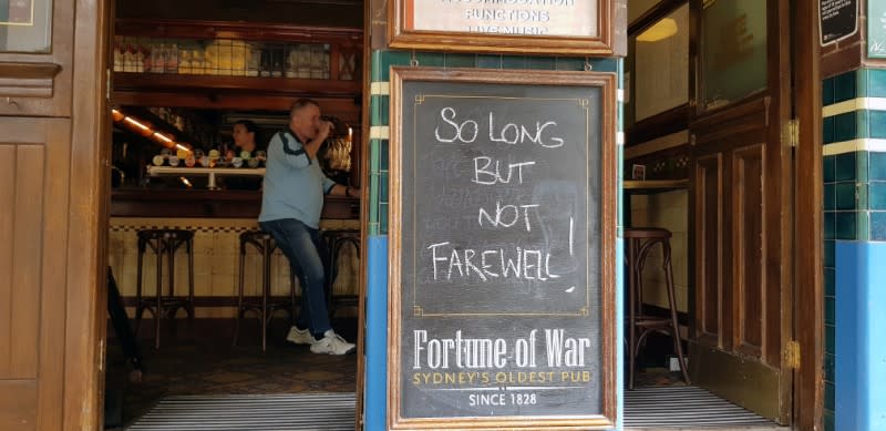 Sign in front of Fortune of War pub reads 'so long but not farewell' before it shut down due to coronavirus concerns, in Sydney