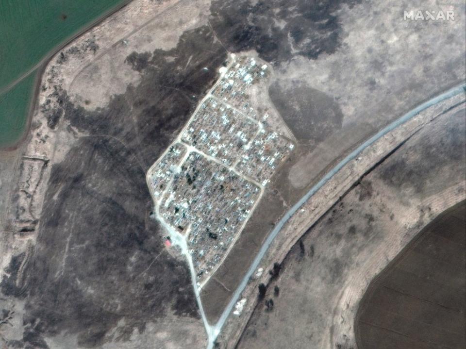 This satellite image provided by Maxar Technologies shows a cemetery before the expansion of graves near Vynohradne (AP)