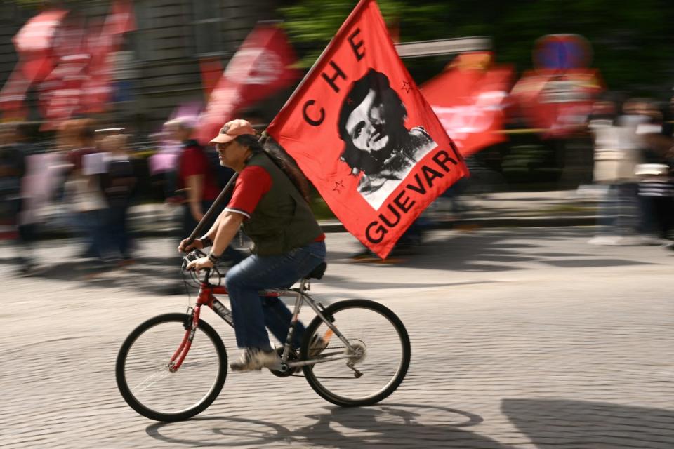 A protester on a bicycle waving a flag depicting Argentinian revolutionary Che Guevara during an International Workers’ Day demonstration in Strasbourg, France, on 1 May 2024 (Sebastien Bozon/AFP/Getty)