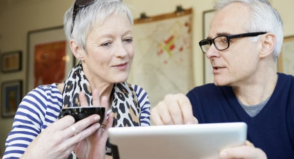 mature man and woman in cafe with digital tablet