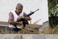 Angel Vivas, a retired army general and anti-President Nicolas Maduro protester, stands in his house with an automatic weapon as he resists being detained in Caracas in this February 23, 2014 file photo. REUTERS/Stringer/Files