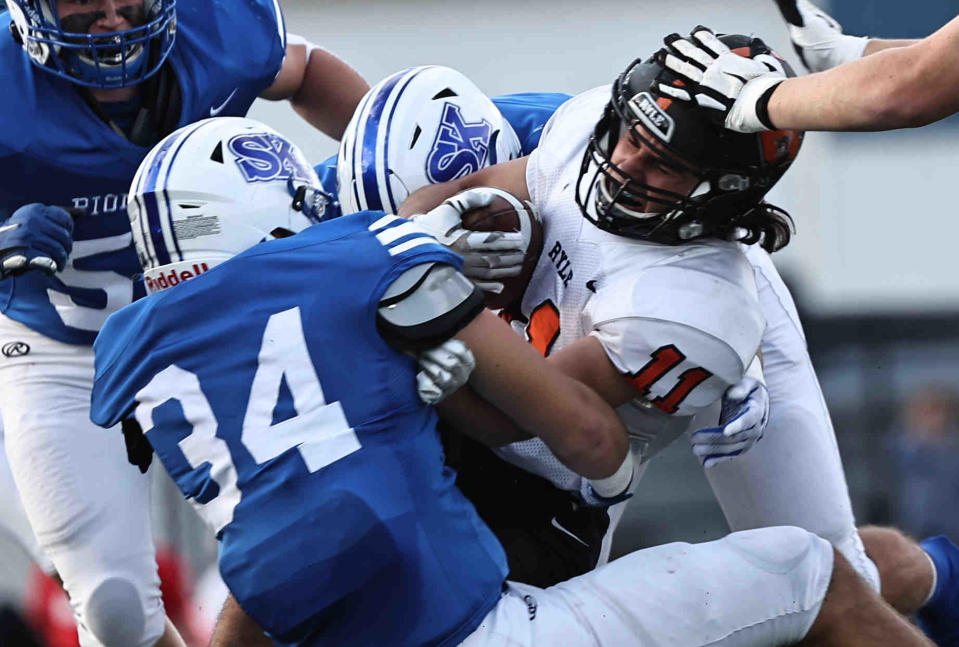 Simon Kenton linebacker Josh Bowling (34) tackles Ryle running back Jayce Harden (11) during their football game Saturday.