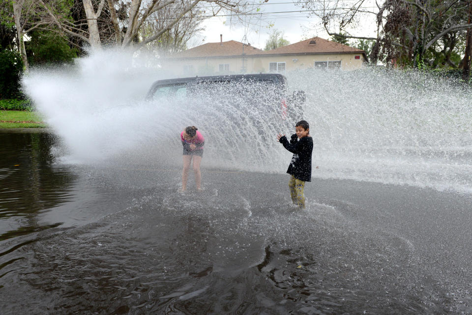 Children get splashed by a passing car while playing in a puddle in Long Beach, Calif., Sunday, March 2, 2014. The storm, the largest since 2010, kept emergency planners and rescue crews busy, but it did not produce enough rain to pull California out of a crippling drought that has grown to crisis proportions for the state's vast farming industry. (AP Photo/The Orange County Register, Anibal Ortiz) MAGS OUT; LOS ANGELES TIMES OUT; MANDATORY CREDIT