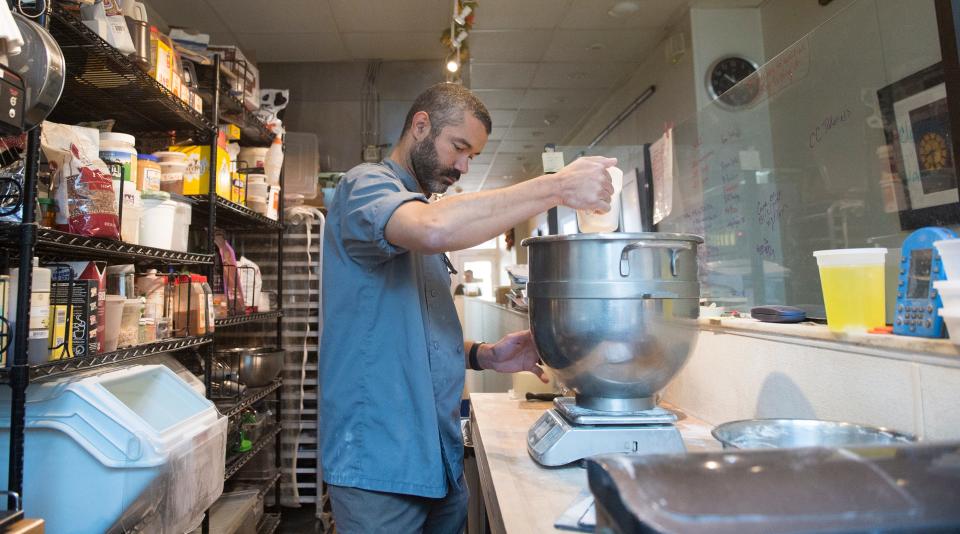 Josué Santiago Negrón, owner and chef of Dulce Artisanal Pastry, compiles ingredients while making a batch of bread in his Collingswood bakery.