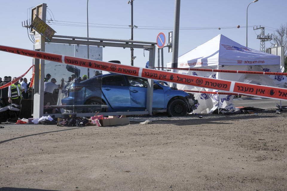 Members of Zaka Rescue and Recovery team and Israeli police forensic team work at the site of a car-ramming attack at a bus stop in Ramot, a Jewish settlement in east Jerusalem, Friday, Feb. 10, 2023. Israeli police say a suspected assailant rammed his car into several pedestrians in east Jerusalem, killing two people and injuring five others before being shot and killed. (AP Photo/Mahmoud Illean)