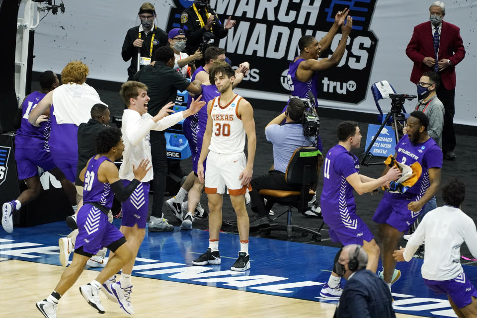 Texas' Brock Cunningham (30) stands on the court as Abilene Christian players celebrate their 53-52 upset win in a college basketball game in the first round of the NCAA tournament at Lucas Oil Stadium in Indianapolis Sunday, March 21, 2021. (AP Photo/Mark Humphrey)