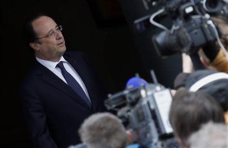 France's President Francois Hollande speaks with journalists as he arrives at the polling station to vote in the first round in the French mayoral elections in Tulle, center France, March 23, 2014. REUTERS/Regis Duvignau