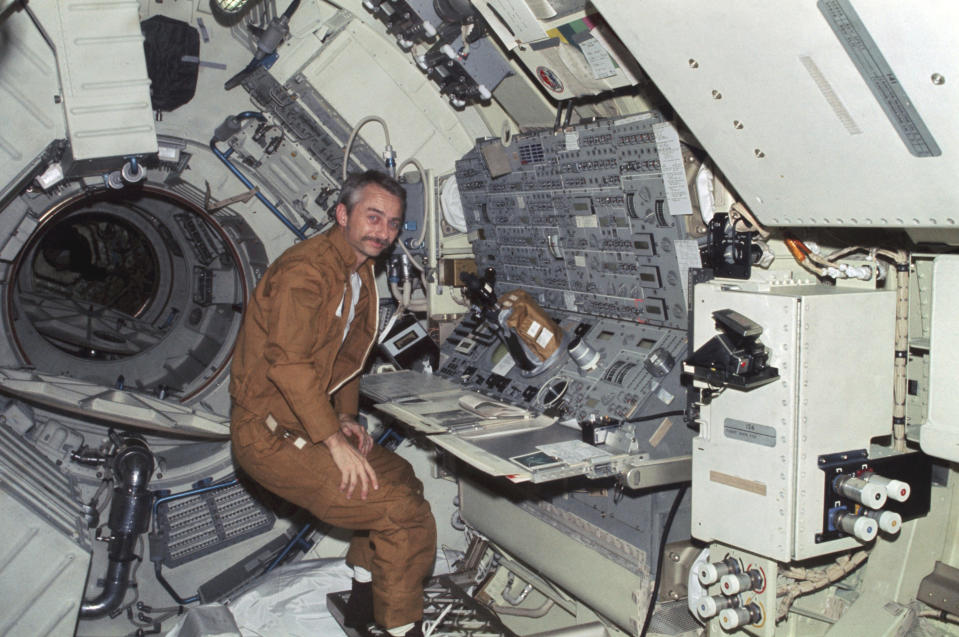 In this 1973 photo made available by NASA, astronaut Owen K. Garriott floats in front of the Apollo Telescope Mount console in the Multiple Docking Adapter of the Skylab space station in Earth orbit. The space agency said Garriott died at his home in Huntsville, Ala., on Monday, April 15. 2019. He was 88. (NASA via AP)