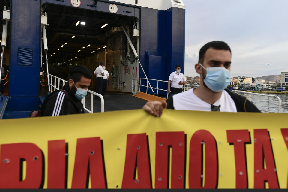 Protesters block the entrance of a passenger ship during a 24-hour labour strike at the port of Piraeus, near Athens, Thursday, June 10, 2021. Greece's biggest labor unions stage a 24-hour strike to protest a draft labor bill being debated in parliament, which workers say will erode their rights. (AP Photo/Michael Varaklas)